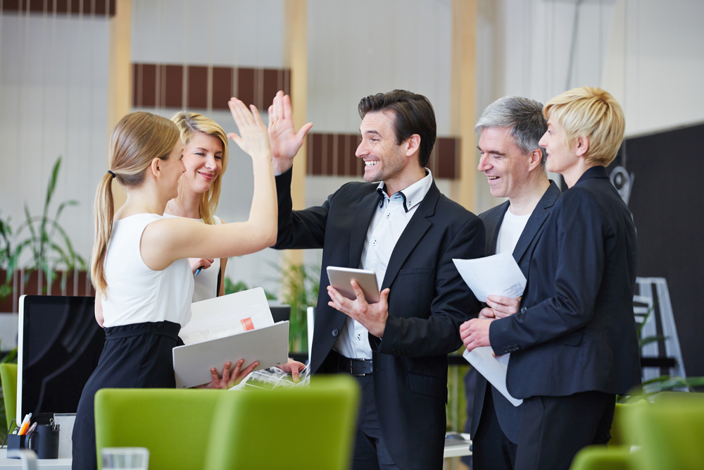 successful team of business people giving high five in the office